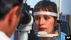 A young woman has her eyes examined by an ophthalmologist.