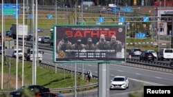 An advertising board, which promotes service in Wagner private mercenary group, is on display on the roadside on the outskirts of Saint Petersburg, Russia, June 7, 2023. (REUTERS/Anton Vaganov)