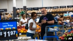 FILE - Shoppers pause in the produce section at a Walmart Superstore in Secaucus, New Jersey, July 11, 2024. 