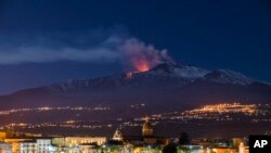 Gunung berapi paling aktif di Eropa, Gunung Etna, memuntahkan lava saat erupsi pada dini hari Selasa, 11 April 2017, dengan latar depan kota Sicilia, Riposto, Italia. (Foto: dok).