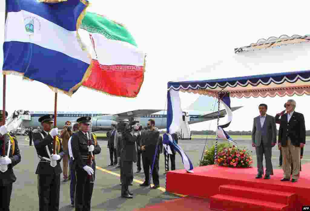 Mr. Ahmadinejad and Nicaragua's Foreign Minister Samuel Santos (R) stand next to their national flags upon the Iranian president's arrival in Managua January 10, 2012. (Reuters)