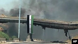 11일 시리아 정부군의 폭격 후 화염이 치솟는 홈스 시. 