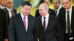 Russian President Vladimir Putin, right, and Chinese President Xi Jinping enter a hall for the talks in the Kremlin in Moscow, Russia, June 5, 2019. 