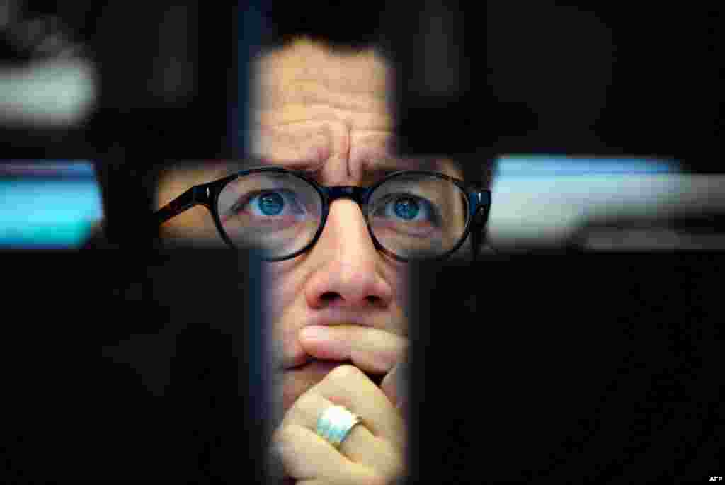 August 10: A broker looks at computer screens at the stock exchange in Frankfurt, Germany, where the stock index DAX went down again. (AP Photo/Patrick Sinkel)