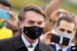 FILE - Brazil's President Jair Bolsonaro leaves his official residence of Alvorada palace in Brasilia, May 25, 2020.