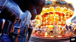 Un policía alemán monta guardia frente a un tiovivo en un mercado navideño en Frankfurt, Alemania. Las medidas de seguridad han aumentado en todo el país.