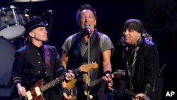 FILE - Bruce Springsteen, center, performs with Nils Lofgren, left, and Steven Van Zandt of the E Street Band during their concert at the Los Angeles Sports Arena in Los Angeles, March 15, 2016. The band's Sept. 7 concert in Philadelphia topped four hours.