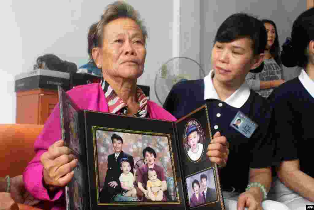 Uma mãe indonésia mostra a fotografia do filho Sugianto Lo e a sua mulher Vinny Chynthya que estavam no avião desaparecido da Malaysia Airlines, Março 10, 2013. 