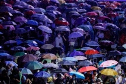 People cover themselves with umbrellas during anti-government protests, in Bangkok, Thailand, Oct. 16, 2020.