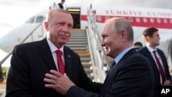 Russia's President Vladimir Putin, right shakes hands with Turkey's President Recep Tayyip Erdogan, prior to his departure from Zhukovsky, outside Moscow, Aug. 27, 2019. 