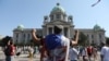 A protester raises his fists in front of the Serbian parliament during an anti-government rally, as deputies attend the first session of the National Assembly after June's national election, Aug. 3, 2020.