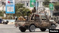 FILE - A Somali security officer holds a position on their open truck near Syl Hotel, the scene of an al Qaeda-linked al Shabaab group's attack in Mogadishu, Somalia, March 15, 2024.
