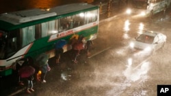 Commuters brave the rain and strong winds brought about by Typhoon Mangkhut, which barreled into northeastern Philippines before dawn, Sept. 15, 2018, in Manila, Philippines. Typhoon Mangkhut, the strongest typhoon to hit the country this year, slammed into the country's northeastern coast early Saturday that forced the evacuation of thousands of residents. 