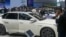 FILE - Visitors look at cars at the BYD booth during the China Auto Show in Beijing, China, Friday, April 26, 2024.