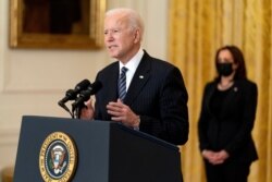 President Joe Biden, accompanied by Vice President Kamala Harris, right, speaks about COVID-19 vaccinations in the East Room of the White House, March 18, 2021, in Washington.