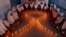 FILE - School girls light candles in the shape of a ribbon during a HIV/AIDS awareness campaign ahead of World Aids Day, in Ahmedabad, India, Nov. 30, 2016.