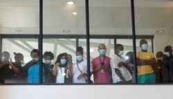 FILE - Health care workers look through a window during the rollout of the first batch of Johnson & Johnson vaccines in the country, at a hospital in Khayelitsha, Cape Town, South Africa, Feb, 17 2021.