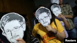 Activistas brasileños utilizan máscaras de Edward Snowden como medida de protesta por las revelaciones que involucran a EE.UU. y sus intervenciones telefónicas a la presidenta de Brasil, Dilma Rousseff.