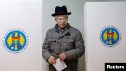 A man leaves a booth before casting his vote during a presidential election at a polling station in Chisinau, Moldova, Oct. 30, 2016. 