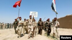 FILE - Popular Mobilisation Forces (PMF) march during a military parade in Daquq, nearby Kirkuk, Iraq, Aug. 5, 2017. 