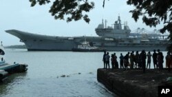 FILE - People watch the INS Vikrant leave for trials in the Arabian Sea in Kochi, India, July 2, 2022. 