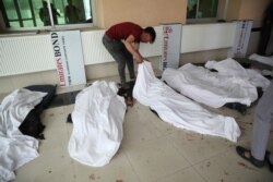A young man try to identify dead bodies at a hospital after a bomb explosion near a school west of Kabul, Afghanistan, May 8, 2021.