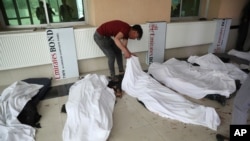A young man tries to identify dead bodies at a hospital after a bomb explosion near a school in a western neighborhood of Kabul, Afghanistan, May 8, 2021. 