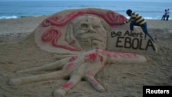 Seniman pasir Sudarshan Pattnaik membuat patung dengan pesan terkait Ebola di pantai di Puri, negara bagian Odisha di India timur (17/10). 