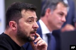 Presiden Ukraina Volodymyr Zelenskyy, kiri, dan Perdana Menteri Belgia Alexander De Croo berpidato pada konferensi media di kantor perdana menteri di Brussels, Rabu, 11 Oktober 2023. (Foto: via AP)