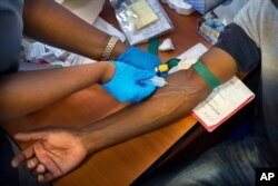 FILE - Blood is drawn from a clinical trials patient for the AstraZeneca test vaccine at the a hospital facility outside Johannesburg, South Africa, Nov. 30, 2020.