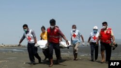 Anggota Palang Merah Myanmar mengevakuasi jenazah supir kendaraan PBB yang diserang saat mengantar sampel tes virus corona di Sittwe, negara bagian Rakhine, 21 April 2020. 