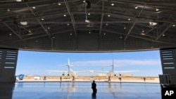 Kru darat Virgin Galactic memandu pesawat masuk ke hangar bandar antariksa Spaceport America setelah uji coba terbang dekat Upham, New Mexico, Kamis, 15 Agustus 2019. (Foto: AP)