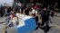 Manifestantes en Chile arrastran un mueble sacado de un negocio para usarlo como barricada en uno de los puntos de protesta en la capital. AP