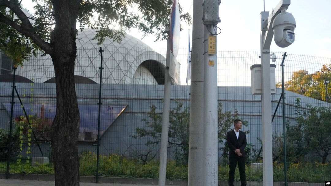 A plainclothes security person stand watch outside the Israeli Embassy in Beijing, Oct. 13, 2023. 