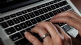 FILE - A person works on a laptop on June 19, 2017, in North Andover, Massachusetts. (AP Photo/Elise Amendola, File)