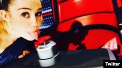 Cyrus escribió en Twitter: "Lamiendo los botones de Xtina! @NBCTheVoice #asesoraclave #temporada10".