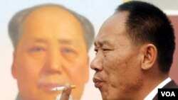 Un hombre camina al lado del otrora líder comunista Mao Zedong en Beijing.