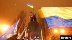 Orang-orang mengibarkan bendera Ukraina dan Uni Eropa di Kyiv. (Foto: Reuters)