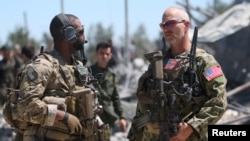 FILE - U.S. forces are seen at the Kurdish People's Protection Units (YPG) headquarters after it was hit by Turkish airstrikes in Mount Karachok near Malikiya, Syria, April 25, 2017. 