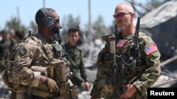 FILE - U.S. forces are seen at the Kurdish People's Protection Units (YPG) headquarters after it was hit by Turkish airstrikes in Mount Karachok near Malikiya, Syria, April 25, 2017. 