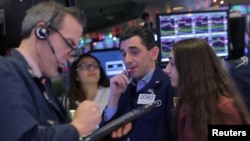 Specialist trader Peter Mazza works with his daughters at his booth on the floor at the New York Stock Exchange during a traditional bring-your-kids-to-work day in New York City, Nov. 23, 2018.