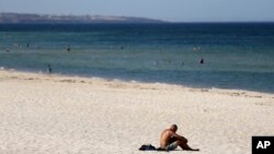 A beachgoer sits in the sun on Glenelg Beach in Adelaide, Australia, Jan. 24, 2019. 