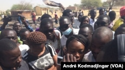 Les étudiants sur les cendres de leur restaurant brûlés par la police entonnant l'hymne national, à N'Djamena, Tchad, le 14 février 2017. (VOA/André Kodmadjingar)