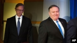 Secretary of State Mike Pompeo, right, followed by Brian Hook, special representative for Iran, walk to a podium to announce the creation of the Iran Action Group at the State Department, in Washington, Thursday, Aug. 16, 2018. (AP Photo/Cliff Owen)