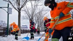 Trabajadores despejan la nieve en una calle en Beijing, el lunes 11 de diciembre de 2023. La nieve caída en buena parte del norte de China provocó cortes de carretera, clases suspendidas y cancelaciones de trenes el lunes. [Foto: AP]