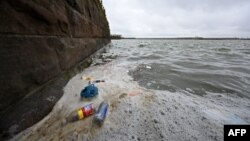 Rubbish including discarded plastic bottles and food wrappers, is pictured floating on the water surface in the Marine Lake at West Kirby in northwest England on April 22, 2024.