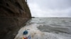 Sampah termasuk botol plastik bekas dan bungkus makanan, mengambang di permukaan air di Danau Laut di West Kirby di barat laut Inggris, 22 April 2024. (Paul ELLIS / AFP)