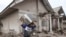 A man carries a television as he evacuates to a safer place following the eruption of Mount Semeru in Lumajang district, East Java province, Indonesia, Dec. 6, 2021. 