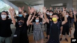 Protesters gesture with five fingers, signifying the "Five demands - not one less" outside a court during a protest in Hong Kong, Thursday, Aug. 27, 2020. Hong Kong police arrested 16 people, including two opposition lawmakers, on Wednesday on…