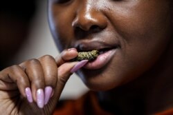 FILE - Customer Gosiame Makoe tastes a mopane worm at the Insect Experience Restaurant in Cape Town, South Africa, Aug. 23, 2019.